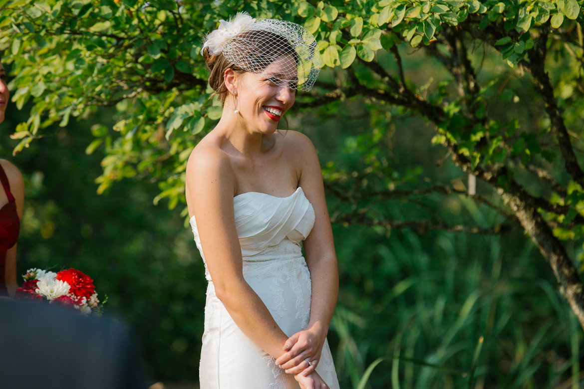 Bride laughing during wedding vows in ceremony at Center for Urban Horticulture in Seattle, WA