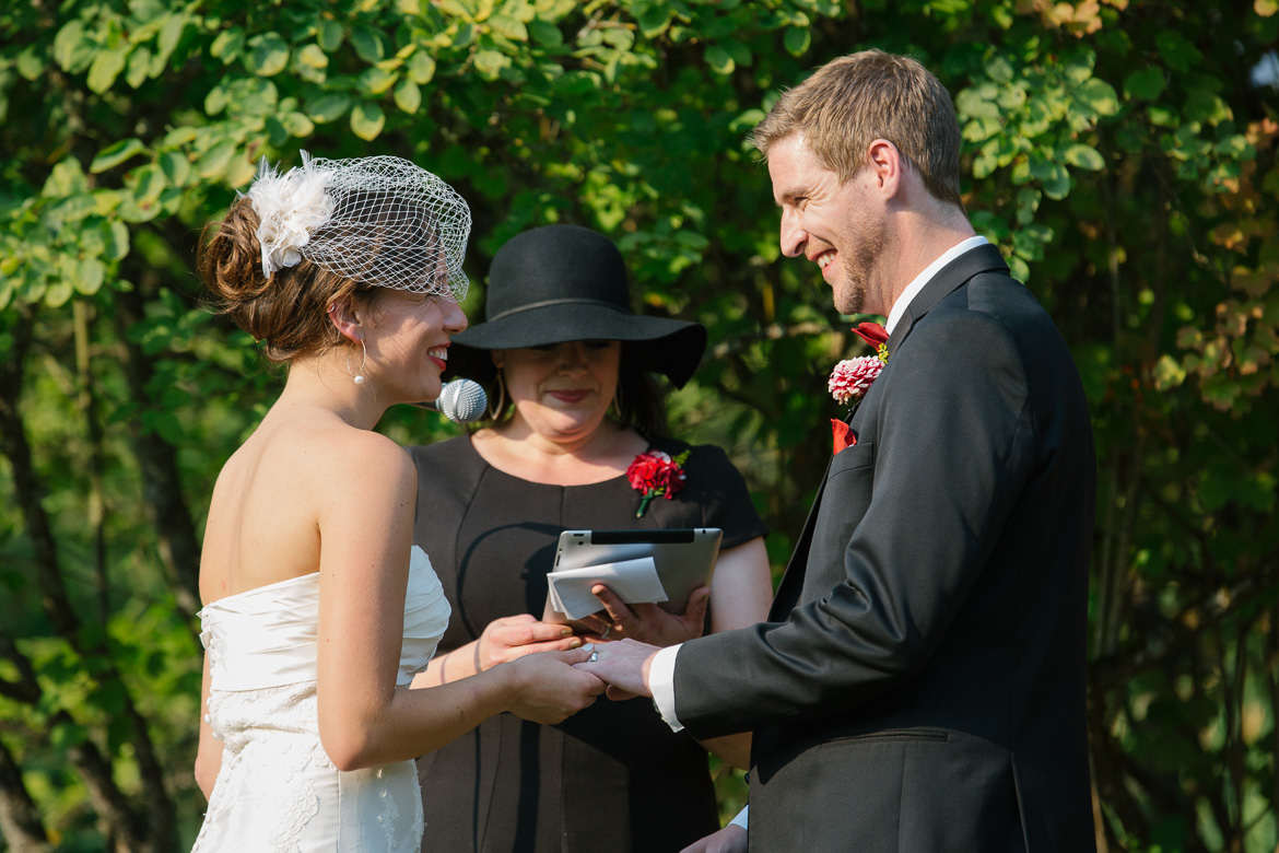 Bride and groom exchanging rings during wedding ceremony at Center for Urban Horticulture in Seattle, WA
