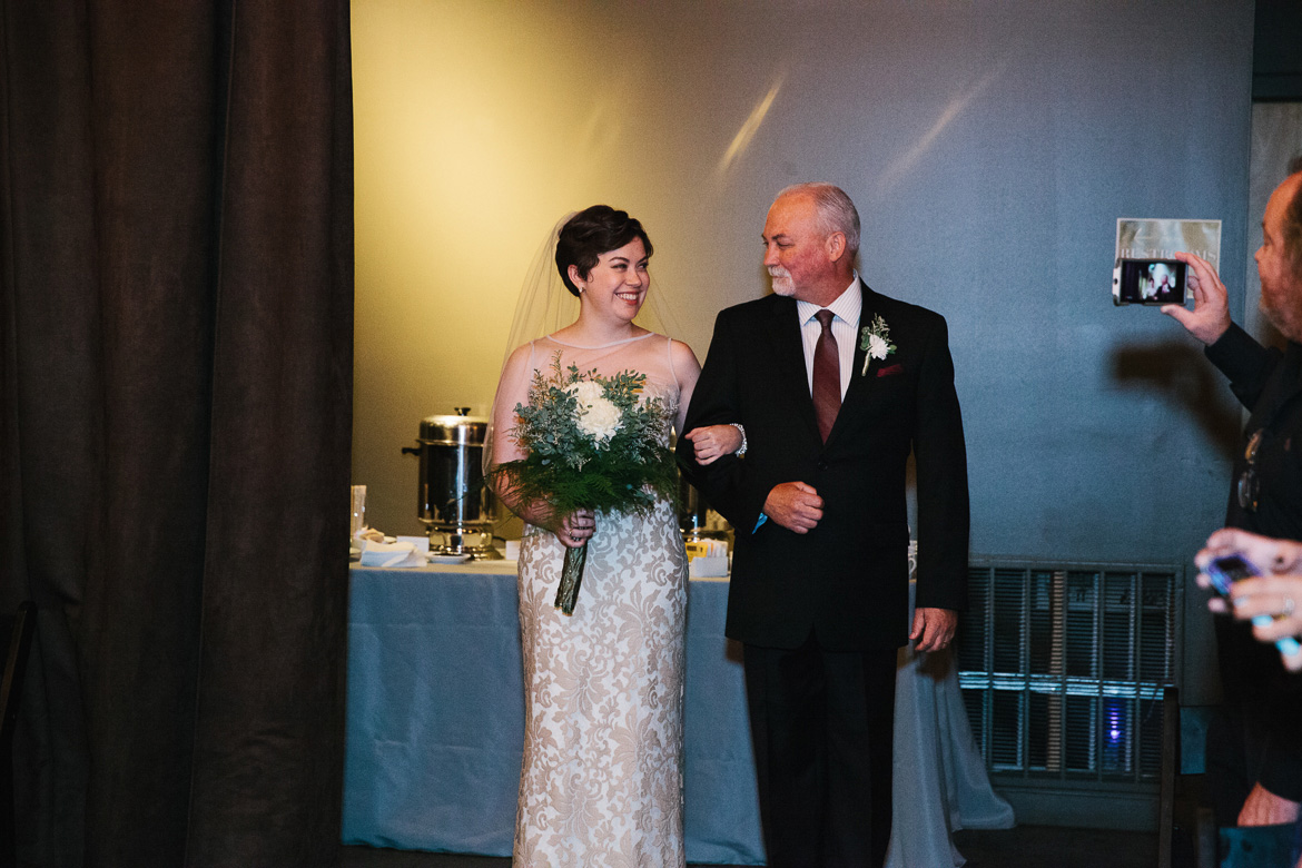 Bride walking down aisle with her father during wedding ceremony at Melrose Market Studios in Seattle, WA