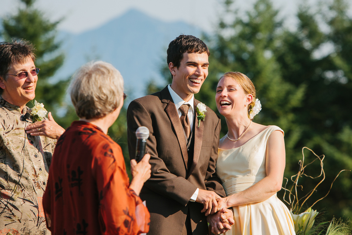 Bride and groom laughing during wedding ceremony at Snoqualmie Point Park with Cascade Mt views
