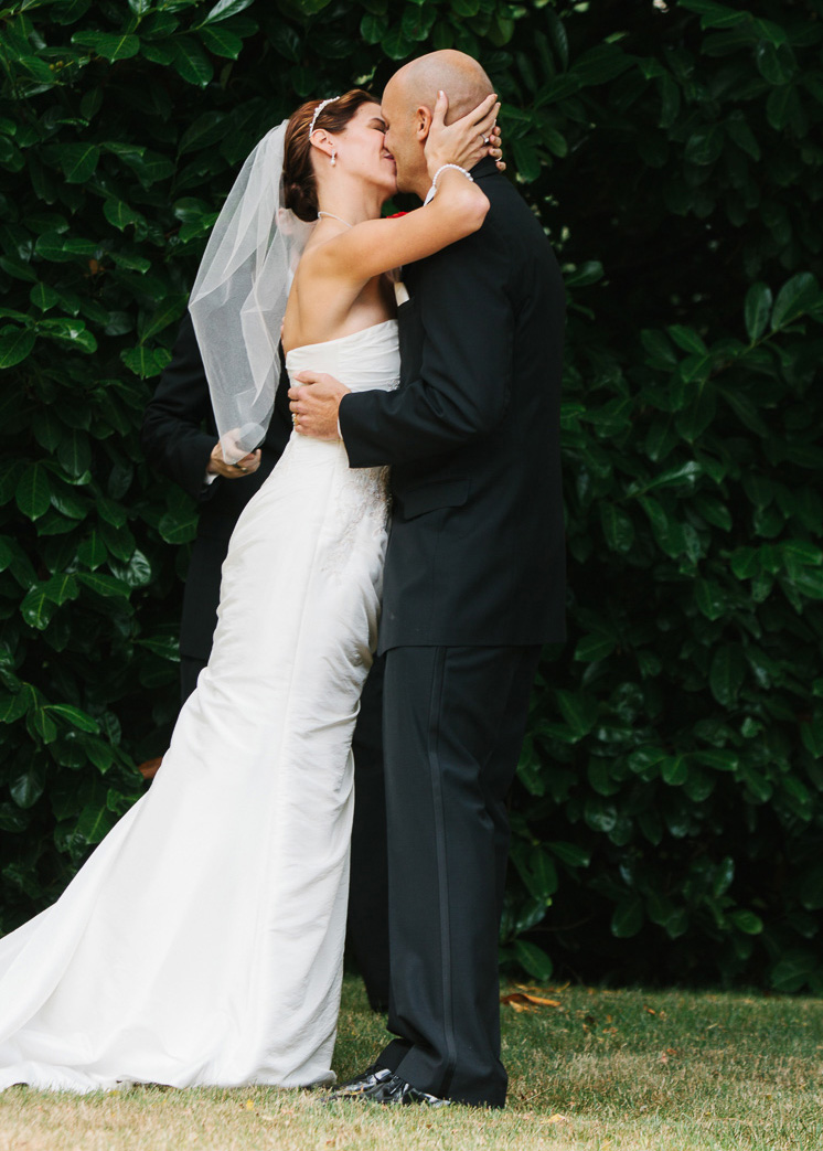 Bride and groom's first kiss during Whidbey Island Winery wedding ceremony in Washington
