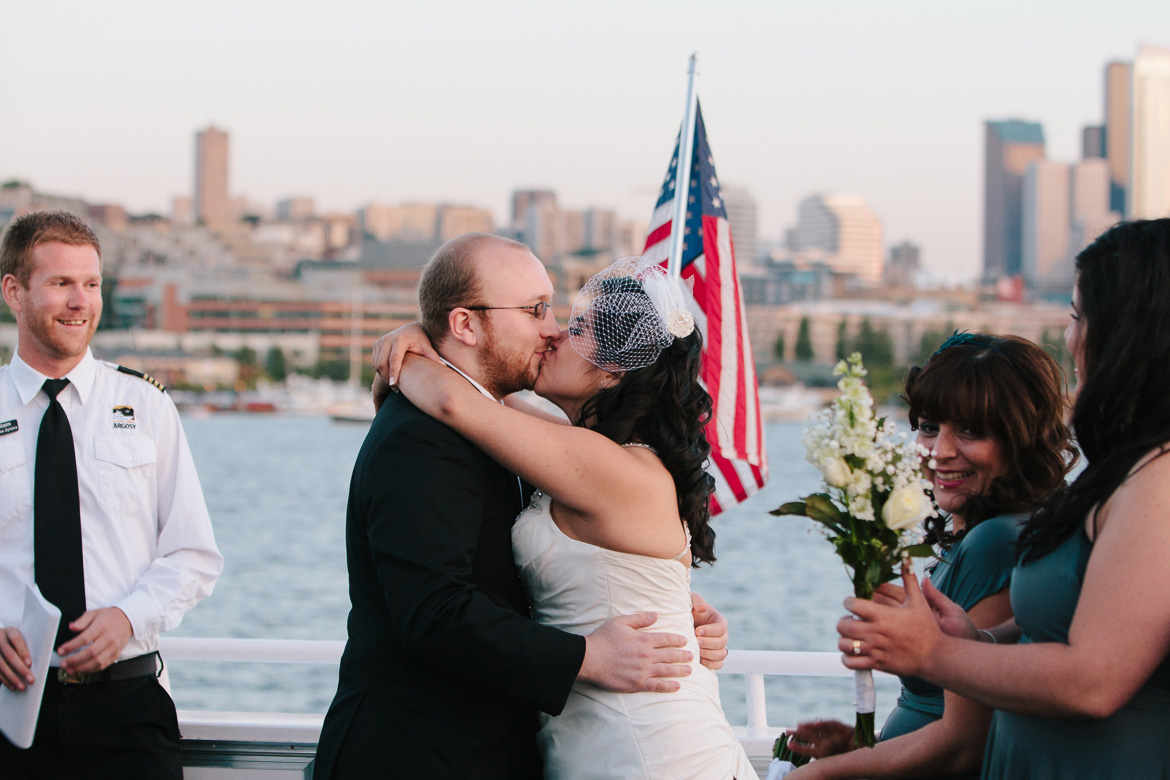 Couple kissing during wedding ceremony on Argosy Cruise wedding in Seattle, WA during wedding photography coverage