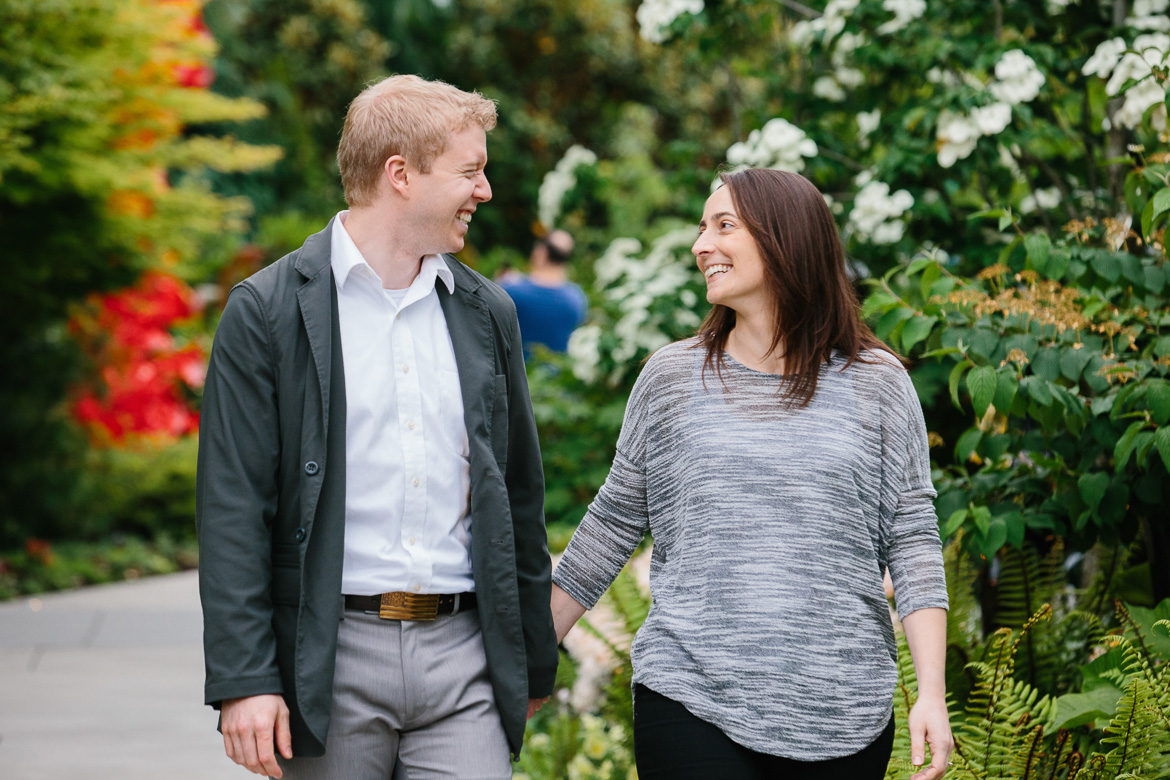 Couple laughing and walking at Chihuly Garden and Glass engagement session in Seattle, WA