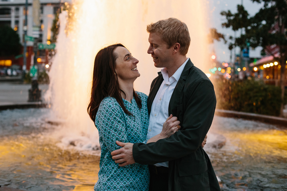 Couple in front of fountain at Olympic Sculpture Park during engagement photos in Seattle, WA