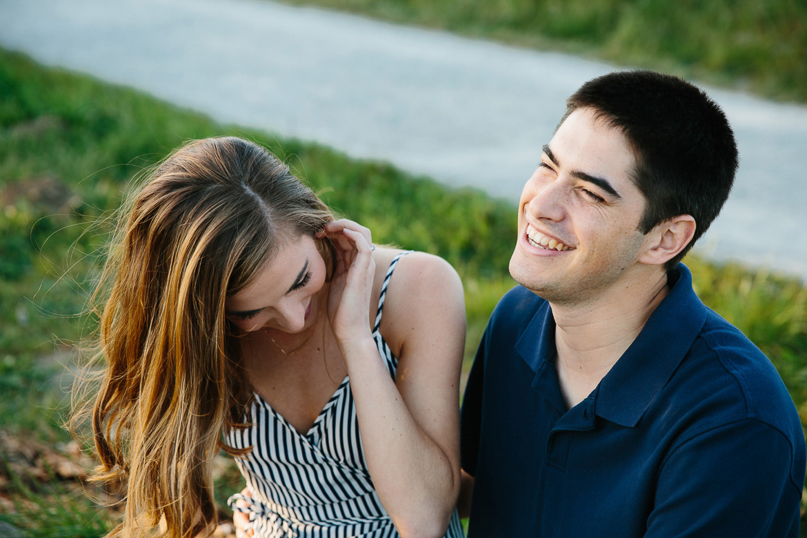 Couple laughing during engagement photos at Discovery Park in Seattle, WA