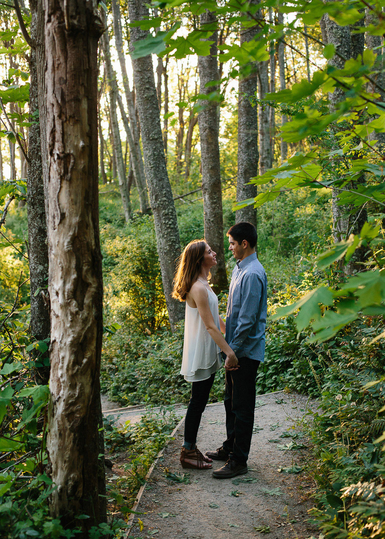 Couple on forest path during sunset engagement photos at Discovery Park in Seattle, WA