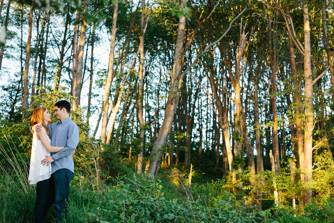 Couple in forest during sunset engagement photos at Discovery Park in Seattle, WA