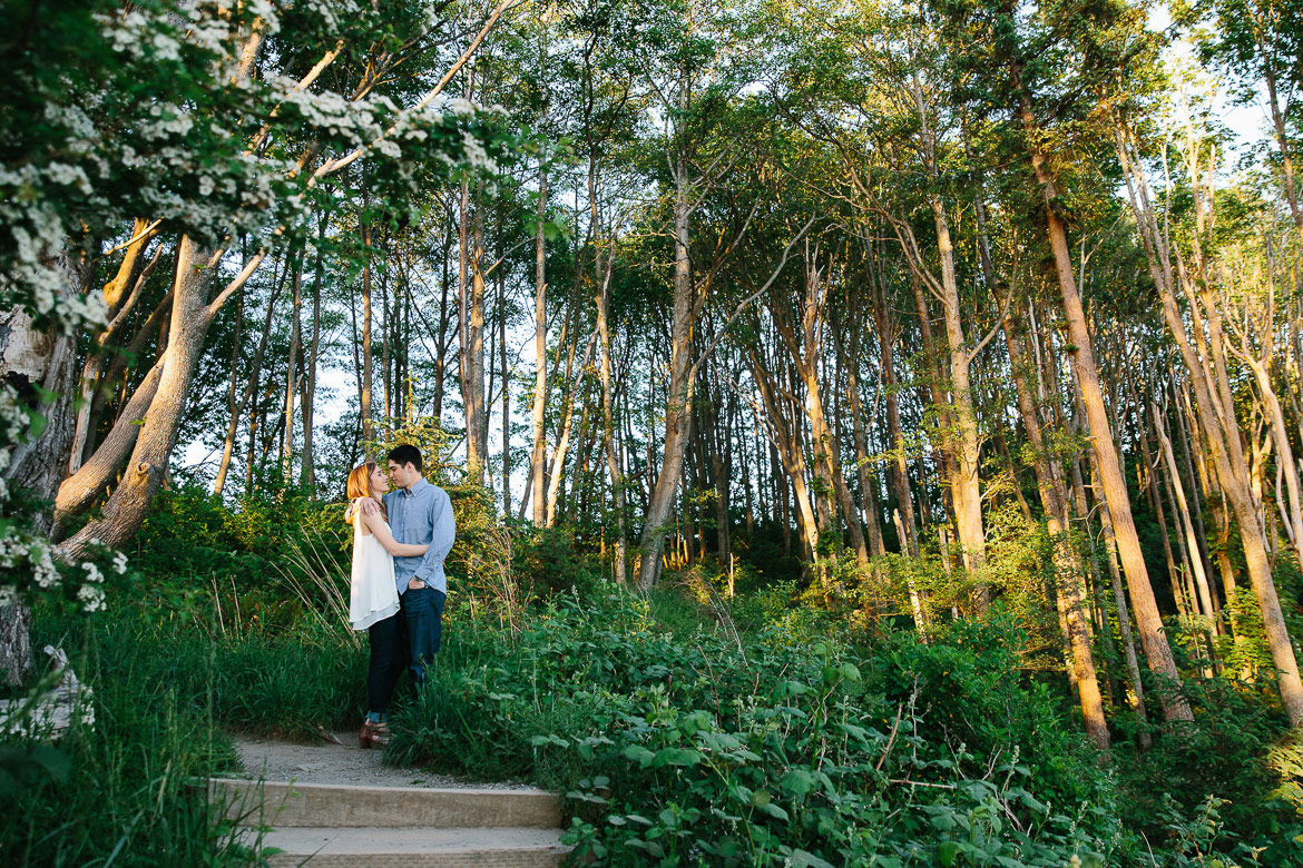 Couple in forest during sunset engagement session at Discovery Park in Seattle, WA