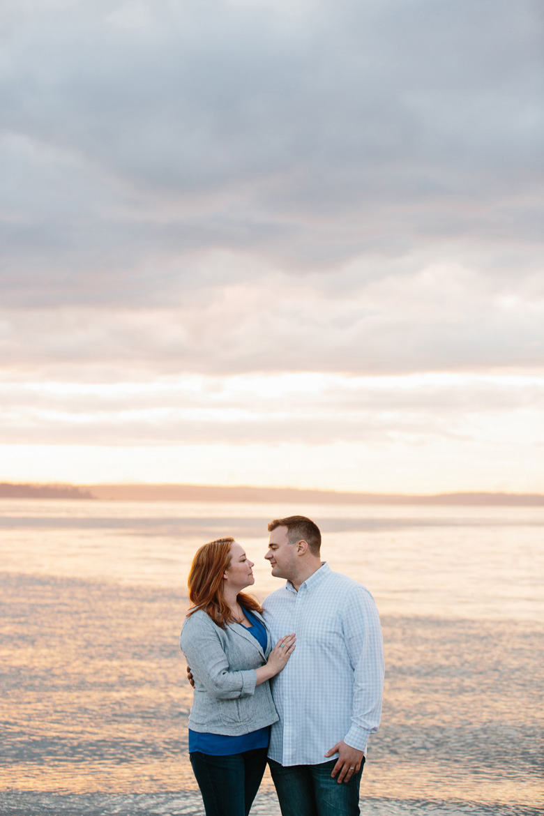 Couple on beach during sunset engagement photos at Discovery Park in Seattle, WA