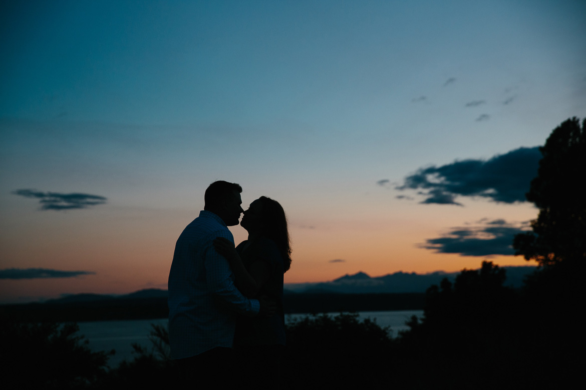 Couple kissing during sunset engagement photos at Discovery Park in Seattle, WA
