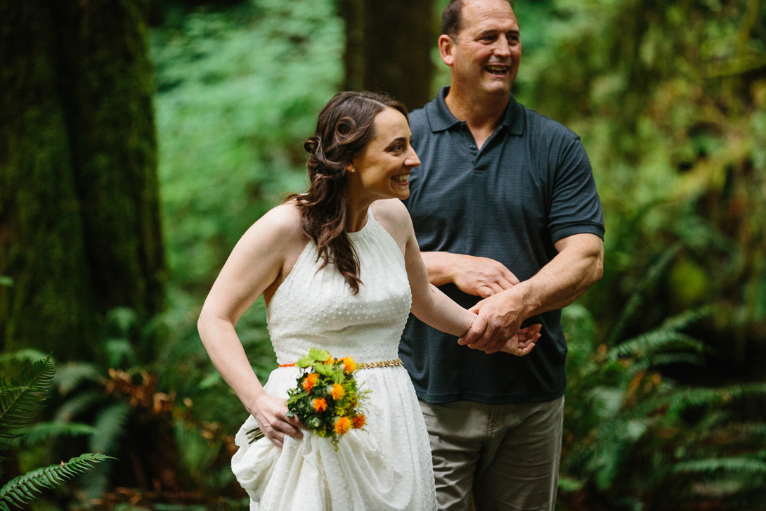 Bride and father of the bride walking in to forest wedding ceremony at Wallace Falls in Gold Bar, WA
