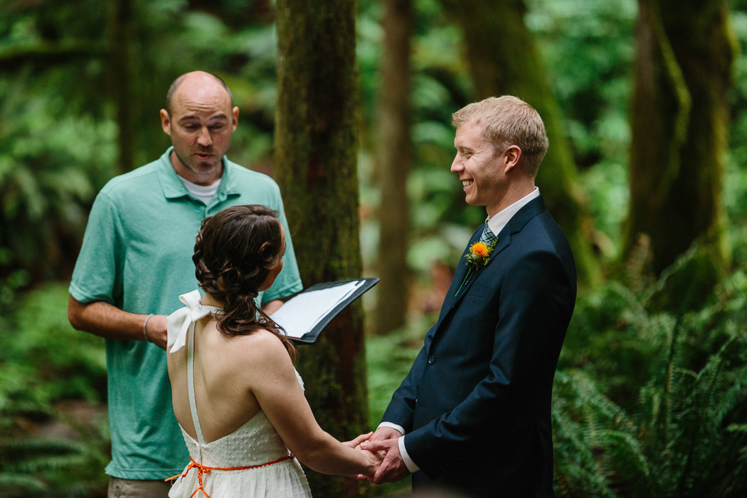 Groom smiling during forest wedding ceremony at Wallace Falls in Gold Bar, WA