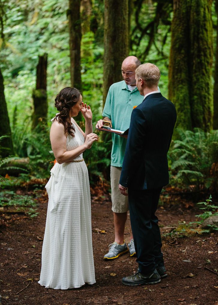 Bride crying with ring during forest wedding ceremony at Wallace Falls in Gold Bar, WA