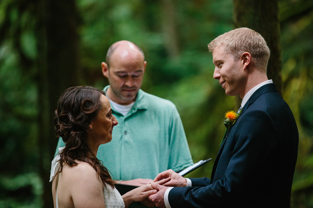 Groom with ring during forest wedding ceremony at Wallace Falls in Gold Bar, WA