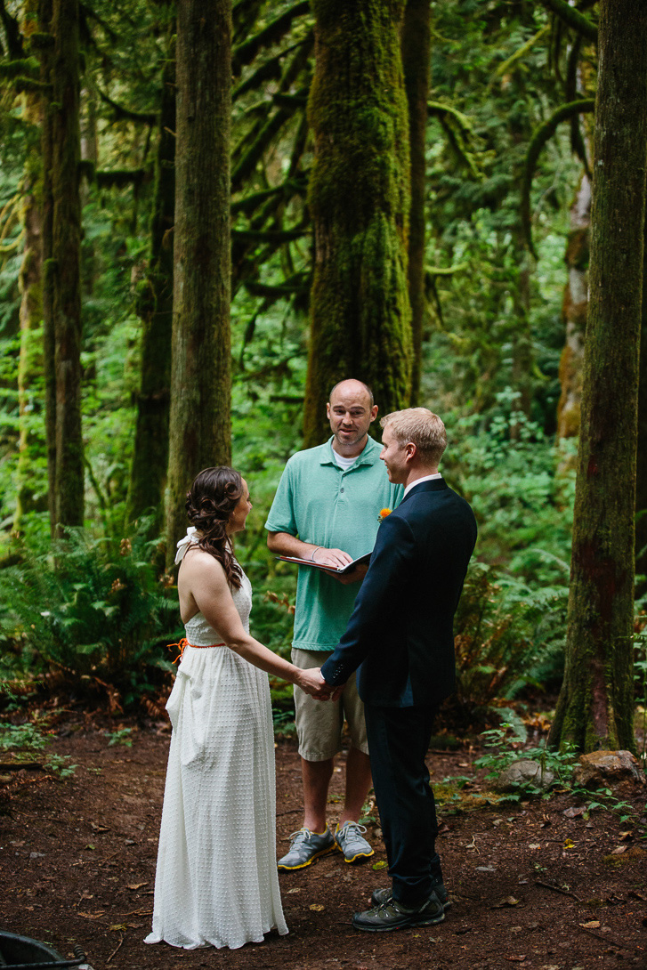 Groom and bride during forest wedding ceremony at Wallace Falls in Gold Bar, WA