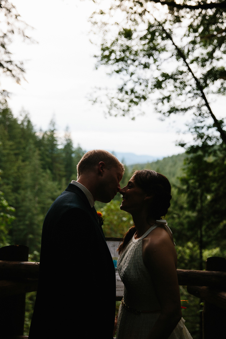 Bride and groom kissing in front of outlook during wedding portraits at Wallace Falls State Park in Gold Bar, WA
