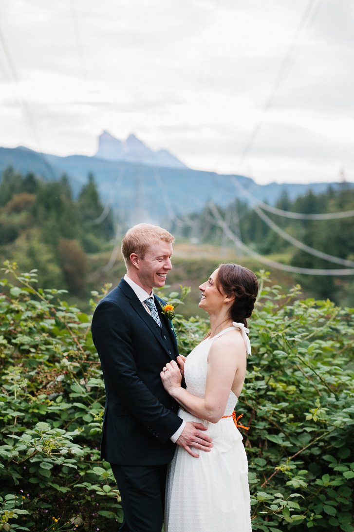 Bride and groom during wedding portraits with view of mountains at Wallace Falls State Park in Gold Bar, WA