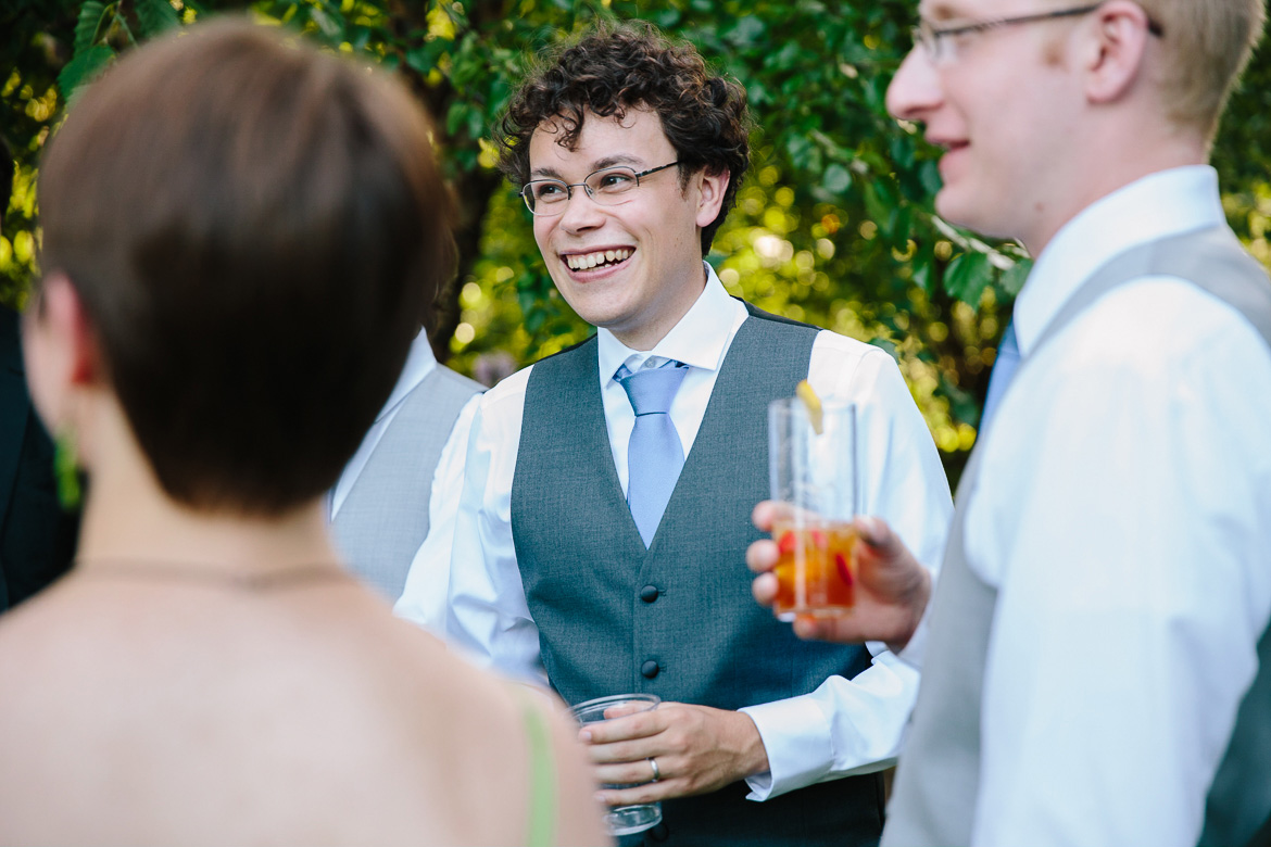 Groom laughing during cocktail hour at Fireseed Catering on Whidbey Island, WA