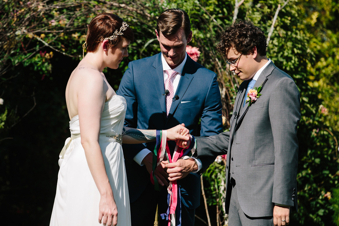 Officient tying ribbons during wedding ceremony at Fireseed Catering on Whidbey Island