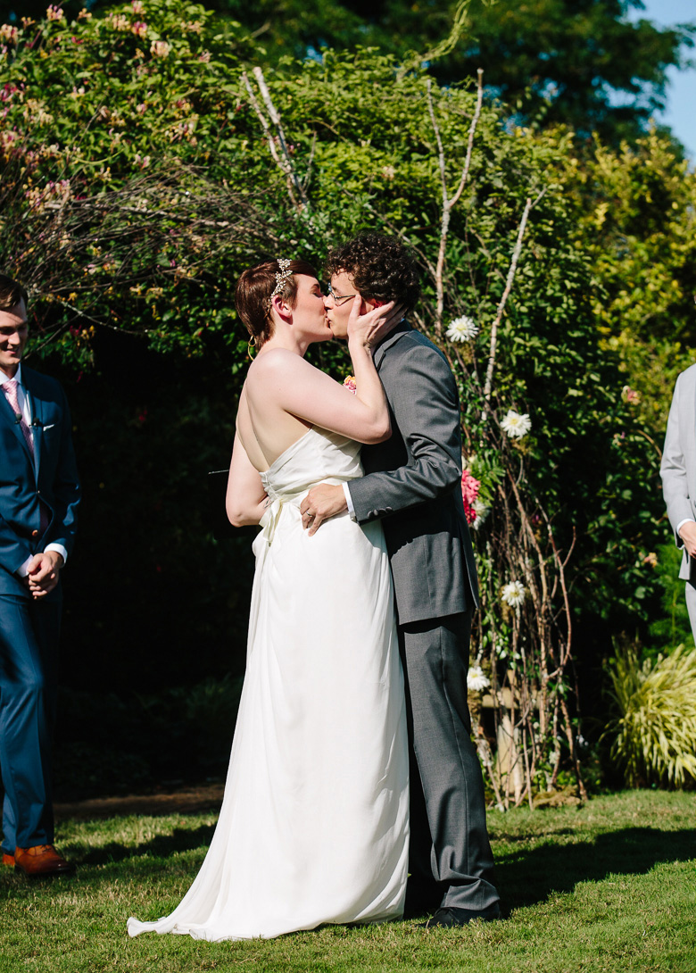 Bride and groom first kiss during wedding ceremony at Fireseed Catering on Whidbey Island, WA
