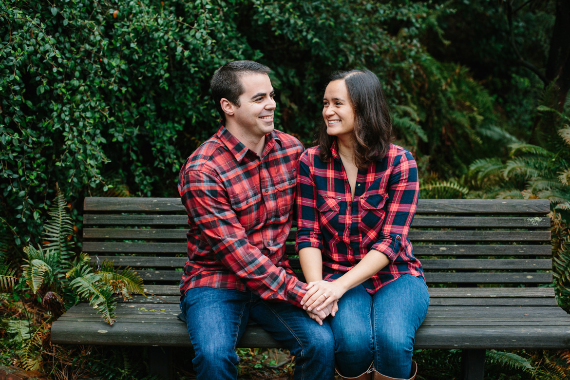 Couple sitting on bench during engagement photos at Seattle University in Washington