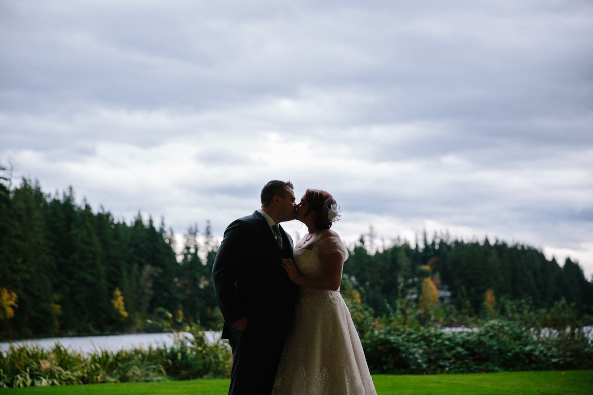 Bride and Groom kissing during portraits on wedding day at Lake Wilderness Lodge in Maple Valley, WA