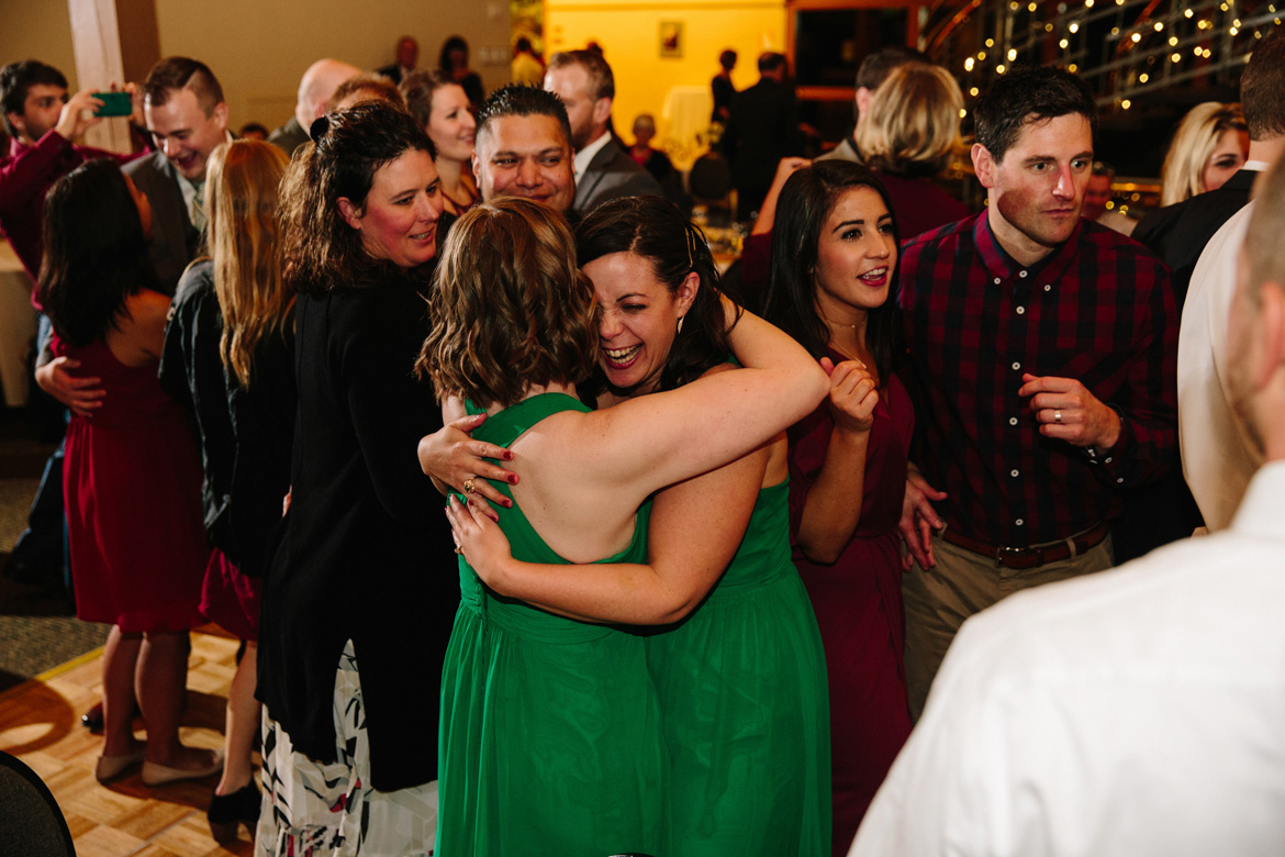 Bridesmaids hugging during wedding reception at Lake Wilderness Lodge in Maple Valley, WA