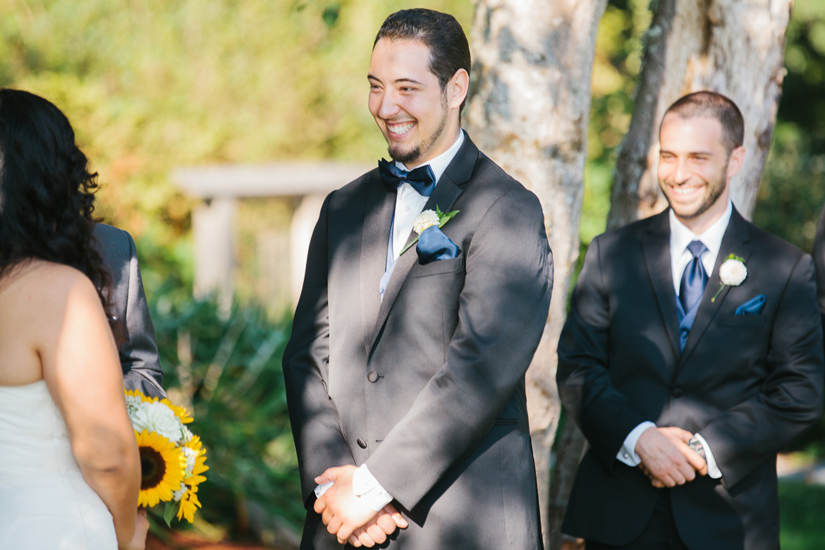 Groom laughing during wedding ceremony at The Cove in Normandy Park, WA