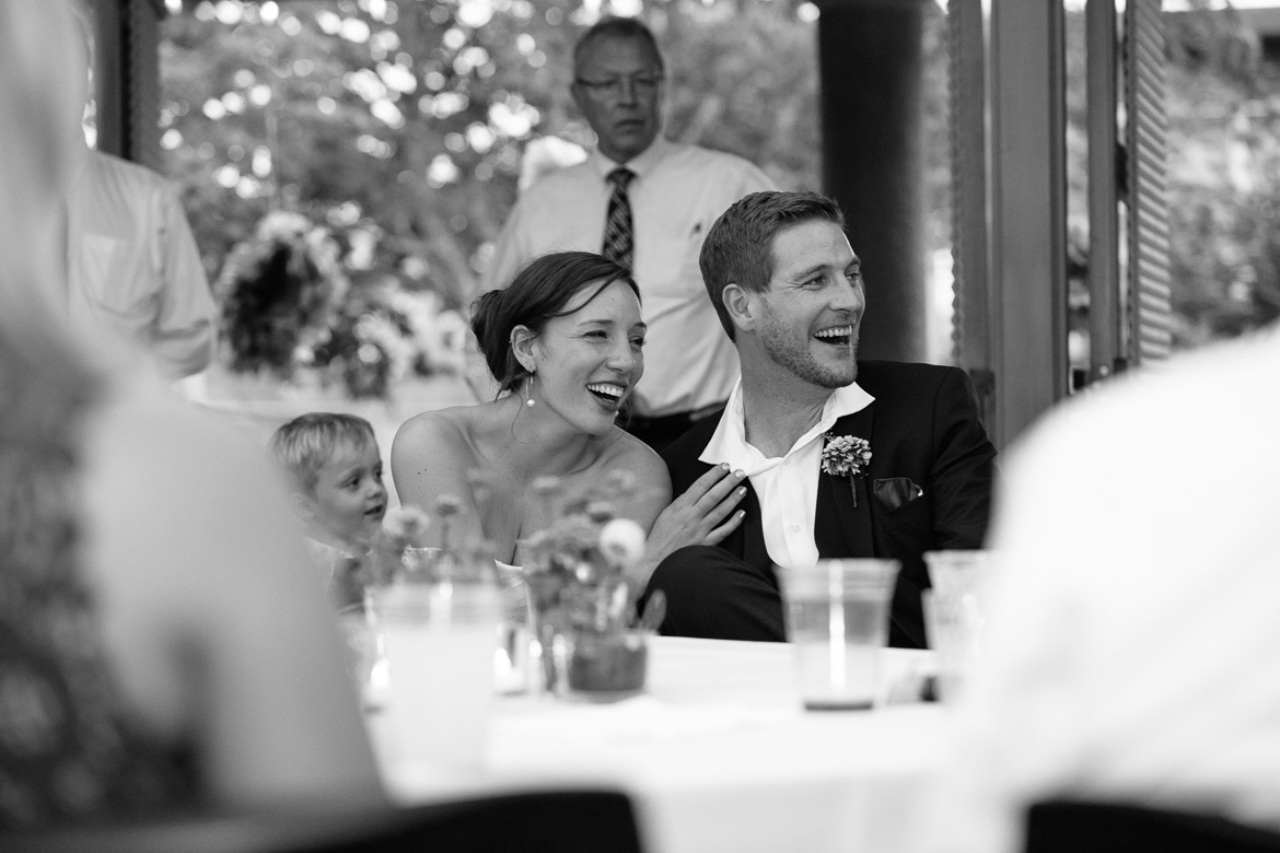 Bride and groom laughing during toasts at wedding reception at Center for Urban Horticulture in Seattle, WA