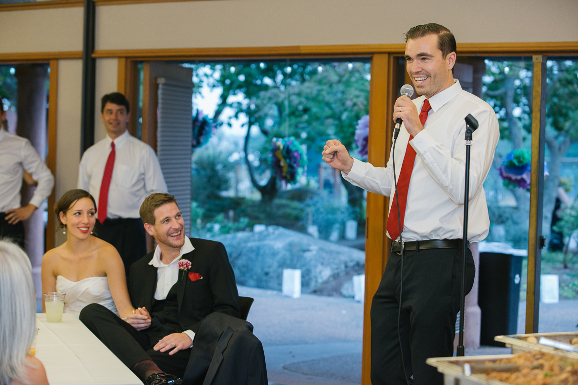 Groomsman laughing during toasts at wedding reception at Center for Urban Horticulture in Seattle, WA