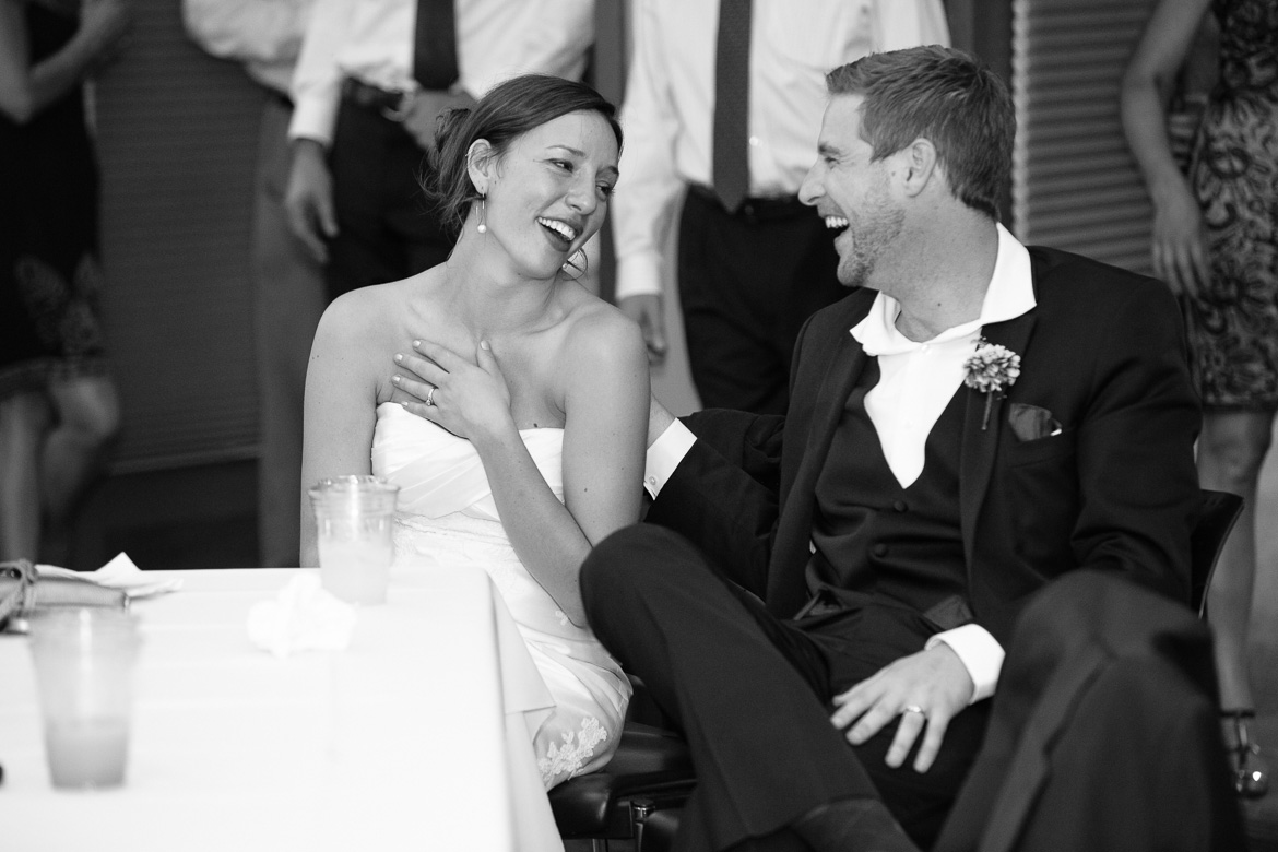 Bride and groom laughing during toasts at wedding reception at Center for Urban Horticulture in Seattle, WA