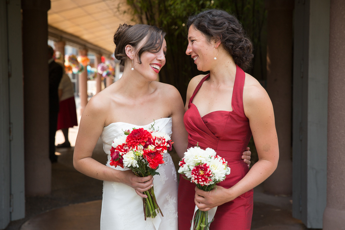 Bride and bridesmaid laughing during portrait before wedding at Seattle Center for Urban Horticulture