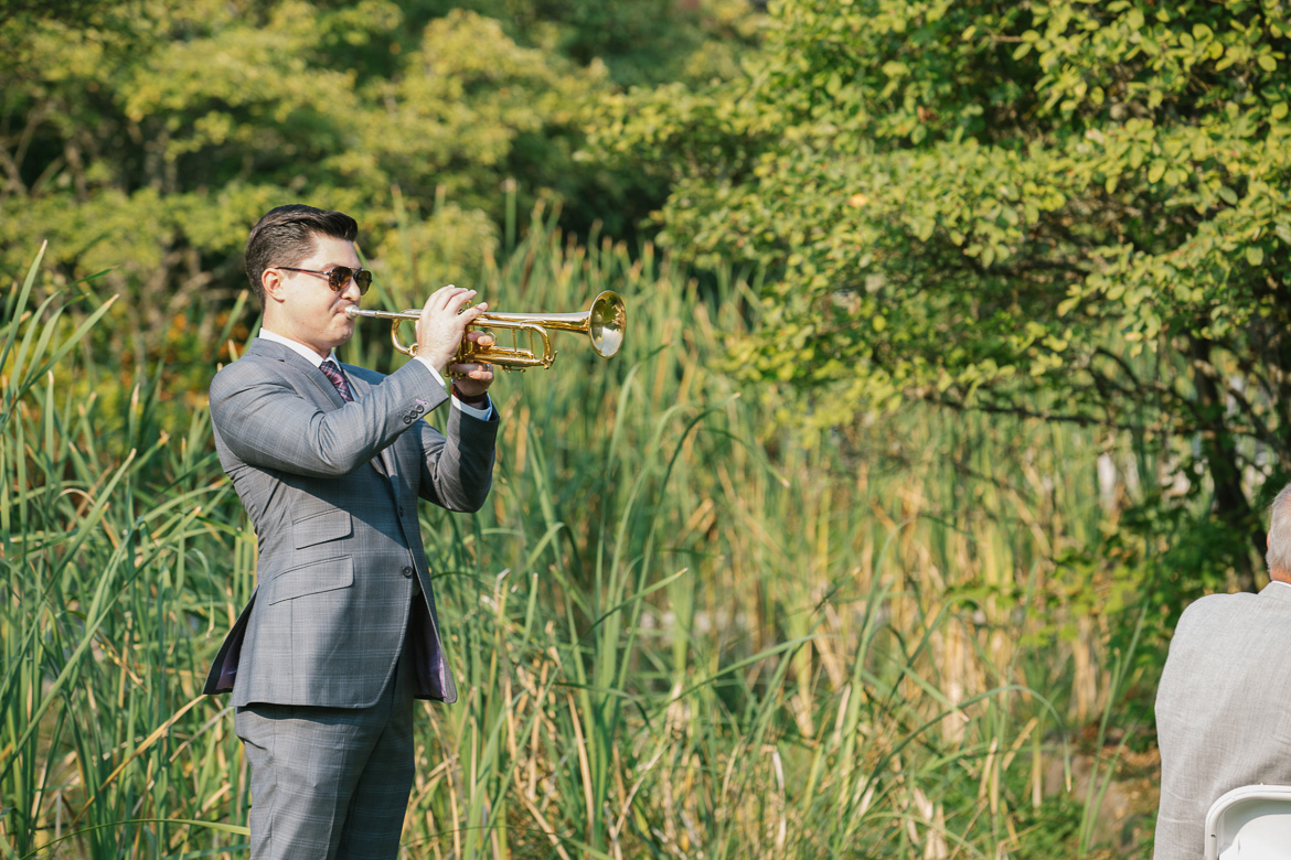 Trumpet player playing for wedding ceremony at Center for Urban Horticulture in Seattle, WA