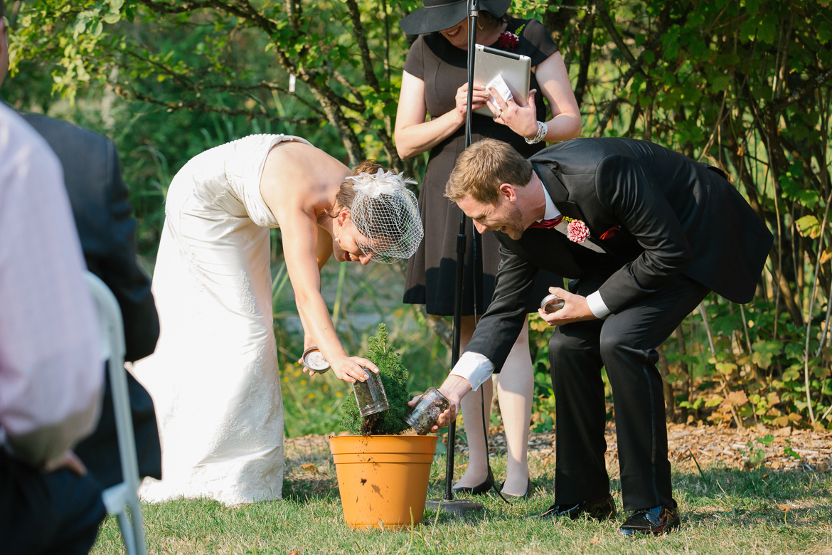 Bride and groom planting tree during wedding ceremony at Center for Urban Horticulture in Seattle, WA