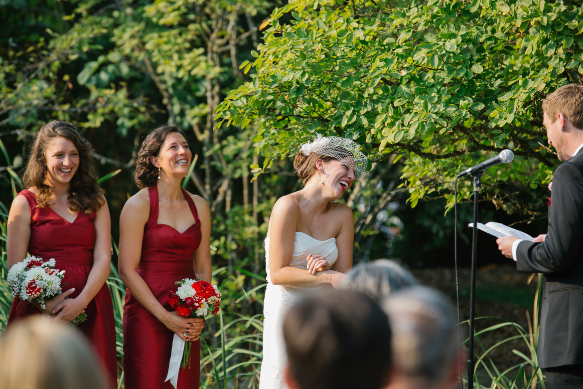 Bride laughing during wedding vows in ceremony at Center for Urban Horticulture in Seattle, WA