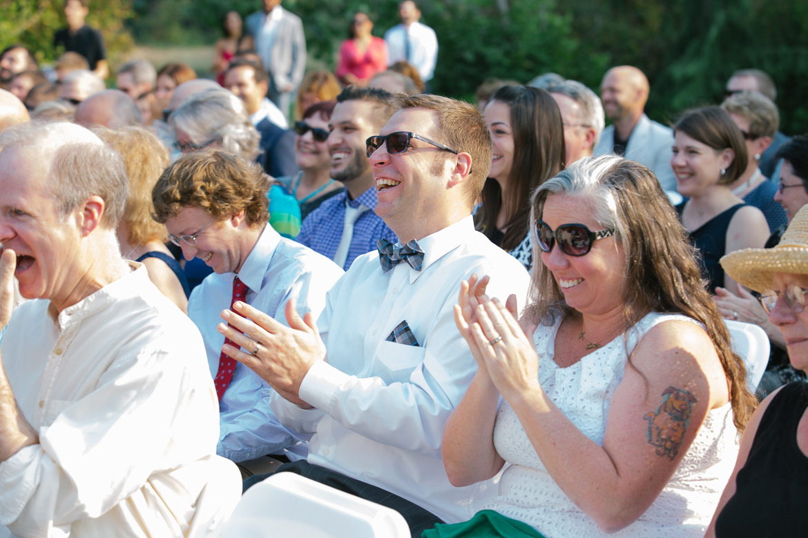 Guests laughing during wedding ceremony at Center for Urban Horticulture in Seattle, WA