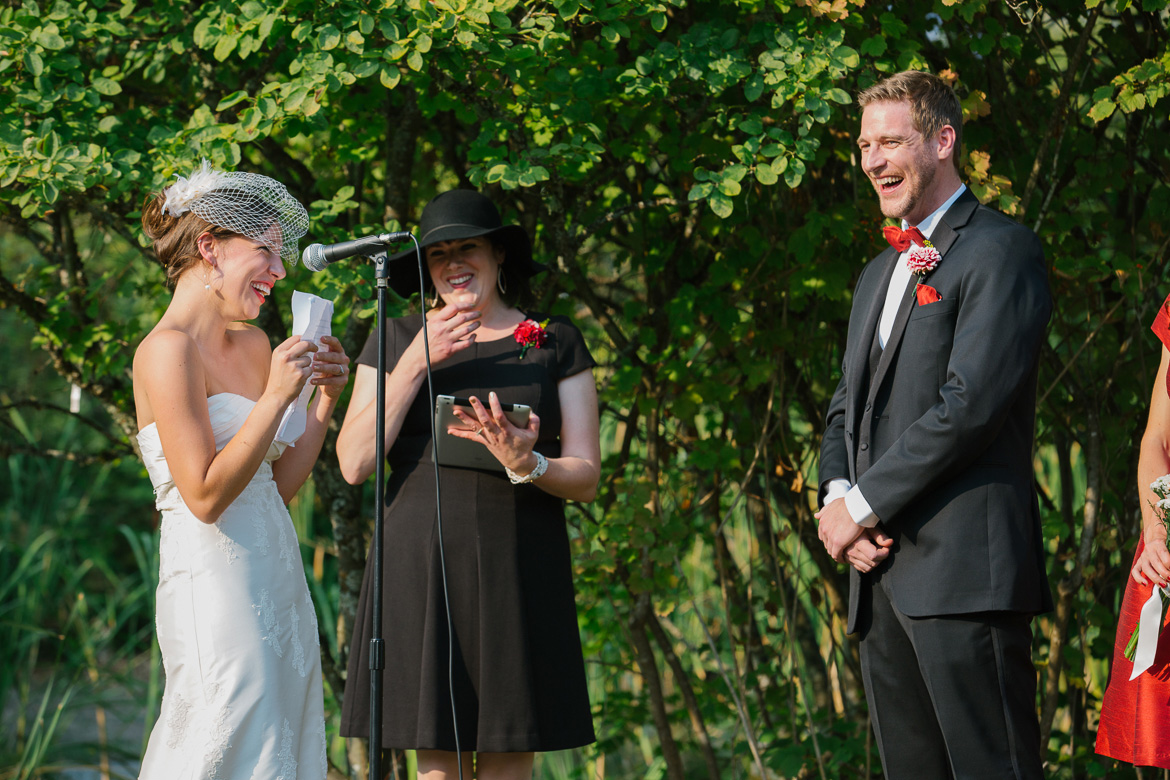 Bride and groom laughing during wedding vows at ceremony at Center for Urban Horticulture in Seattle, WA