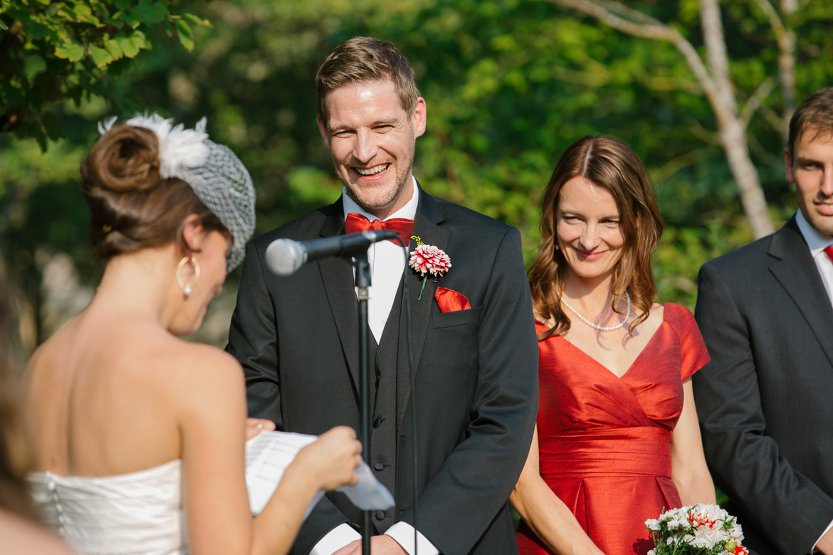 Groom laughing during bride's wedding vows at Center for Urban Horticulture in Seattle, WA