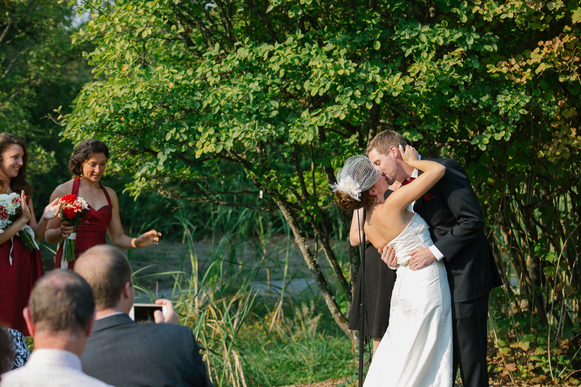 Bride and groom's first kiss during wedding ceremony at Center for Urban Horticulture in Seattle, WA