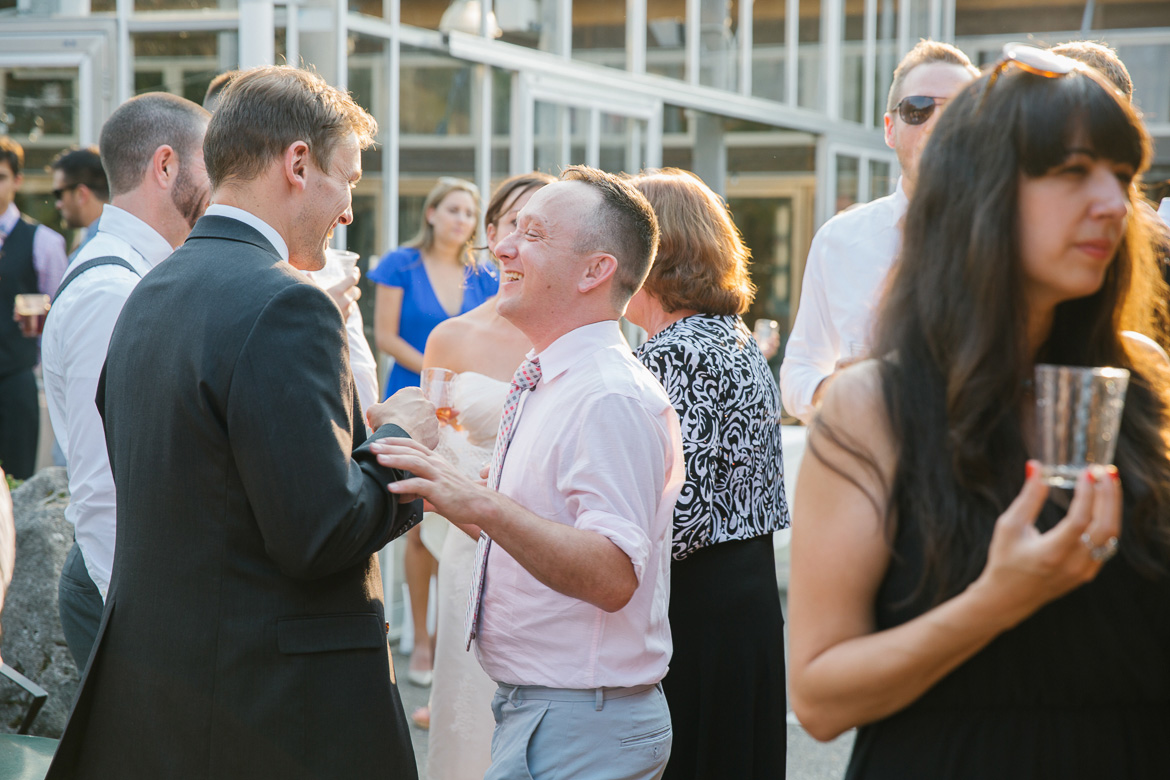 Guests laughing during cocktail hour at wedding at Center for Urban Horticulture in Seattle, WA