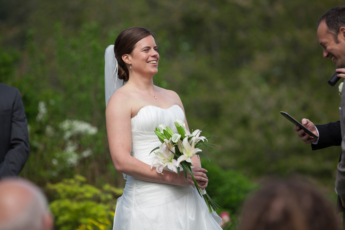 Bride laughing during wedding ceremony at Fireseed Catering on Whidbey Island. WA