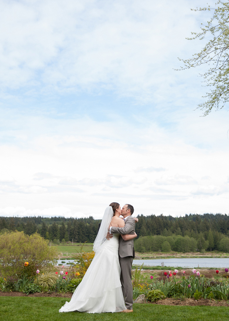 Bride and groom's first kiss during wedding ceremony at Fireseed Catering on Whidbey Island. WA