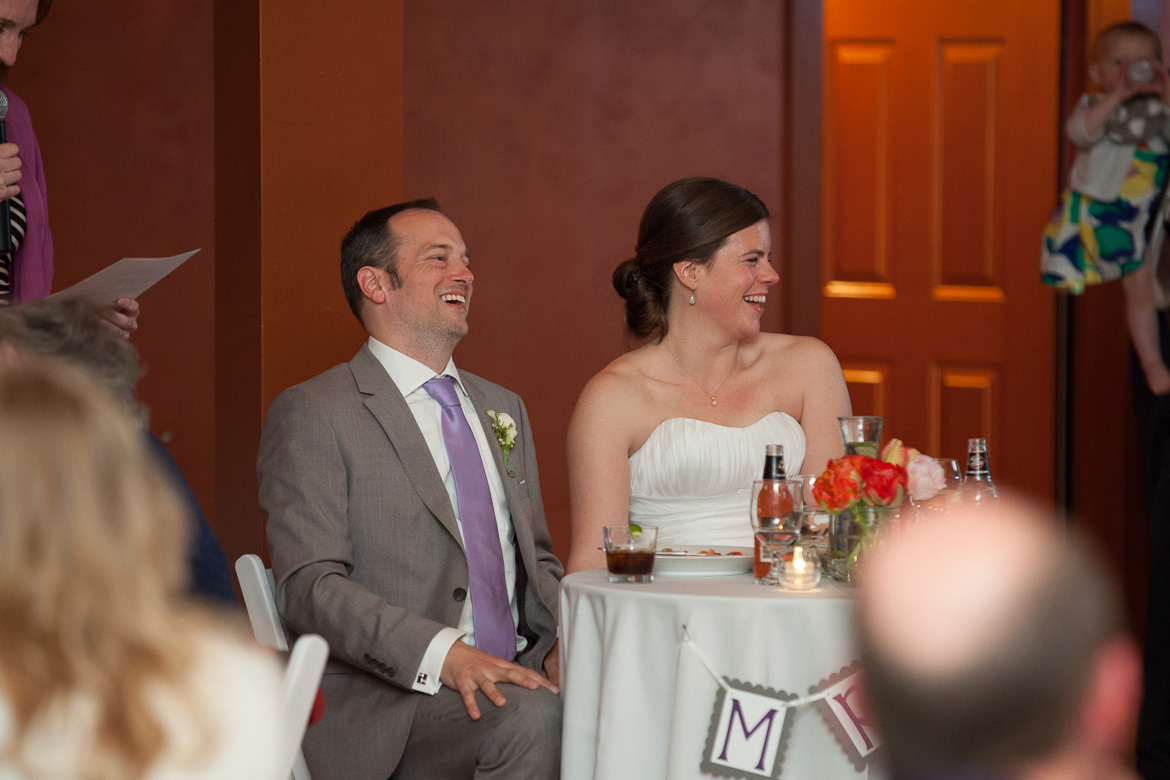 Bride and groom laughing during wedding reception toast at Fireseed Catering on Whidbey Island, WA