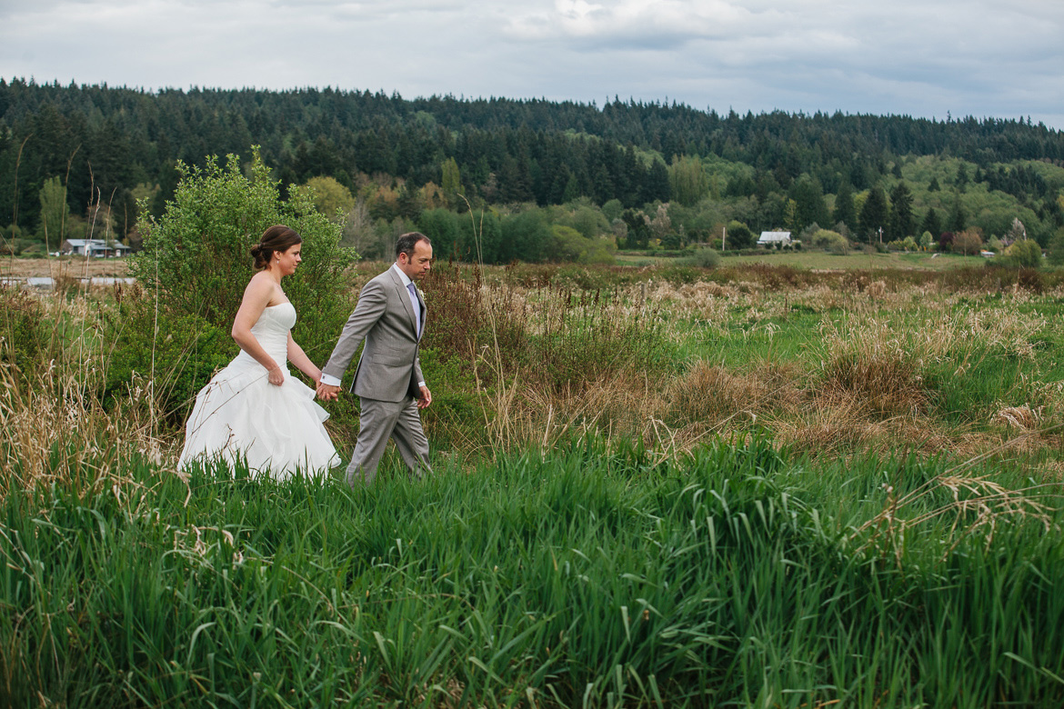 Bride and groom walking during portraits at Fireseed Catering wedding on Whidbey Island, WA during wedding photography coverage