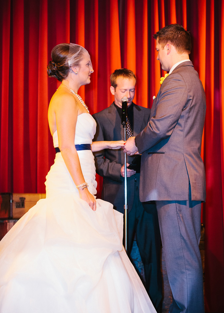 Bride and groom exchanging rings during wedding ceremony at Georgetown Ballroom in Seattle, WA