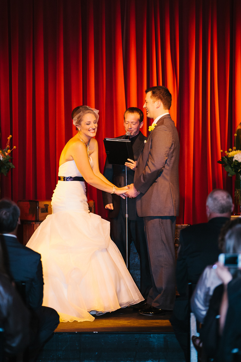 Bride and groom laughing during wedding ceremony at Georgetown Ballroom in Seattle, WA