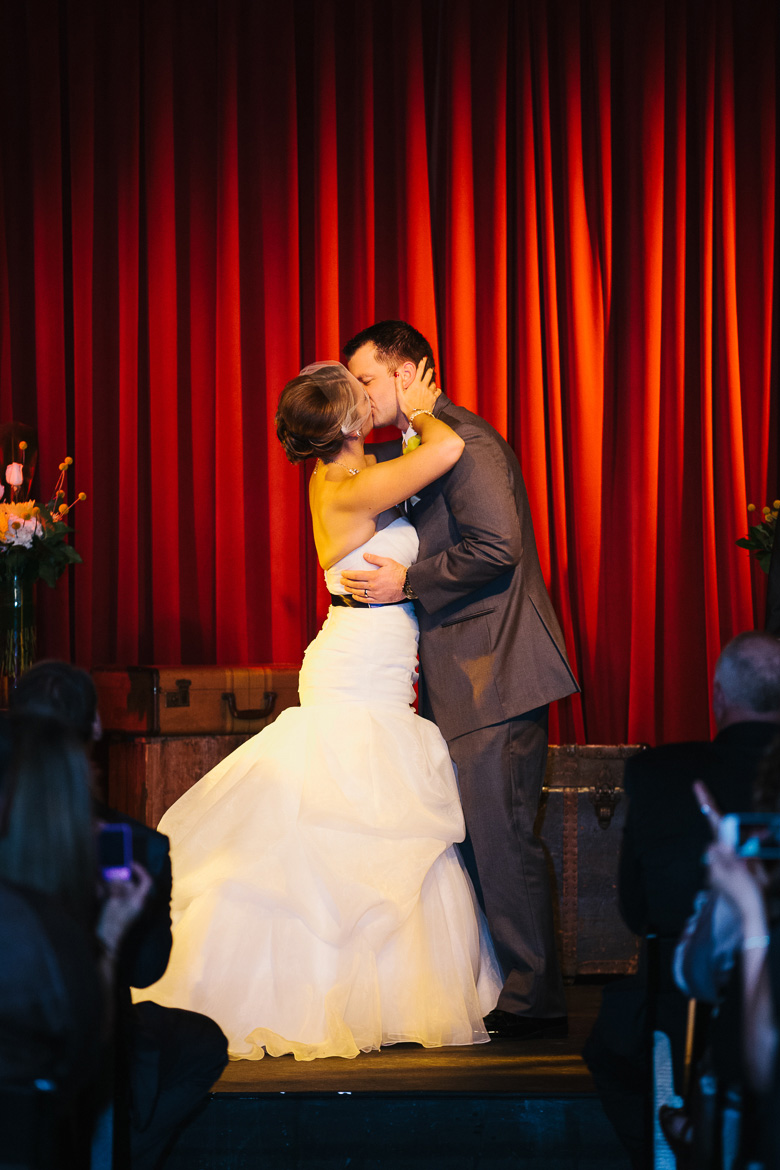 Bride and groom first kiss during wedding ceremony at Georgetown Ballroom in Seattle, WA