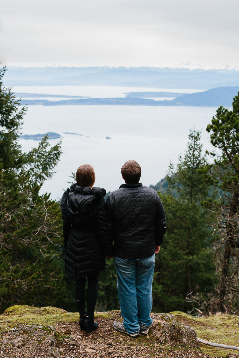 Couple standing during engagement shoot on Mt Constitution with view of San Juan Islands