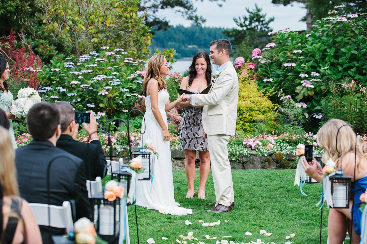 Bride and groom exchanging rings during wedding ceremony at Kiana Lodge in Poulsbo, WA