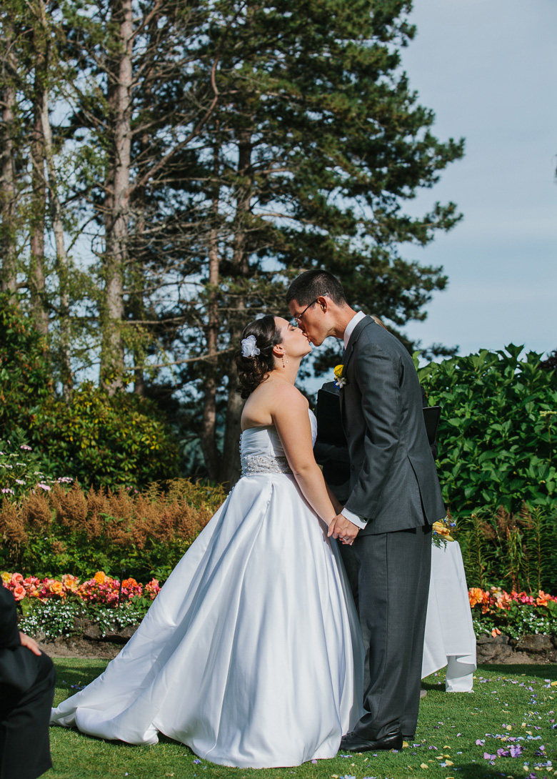 Bride and groom first kiss during wedding ceremony at Kiana Lodge in Poulsbo, WA
